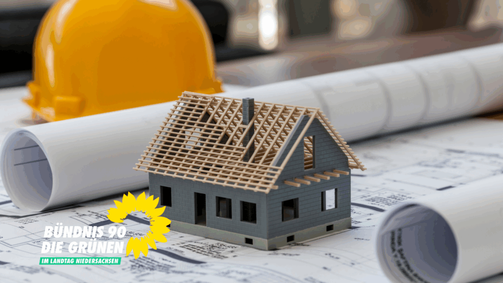 Ein oranger Bauhelm, Baupläne und ein Modell eines Einfamilienhauses