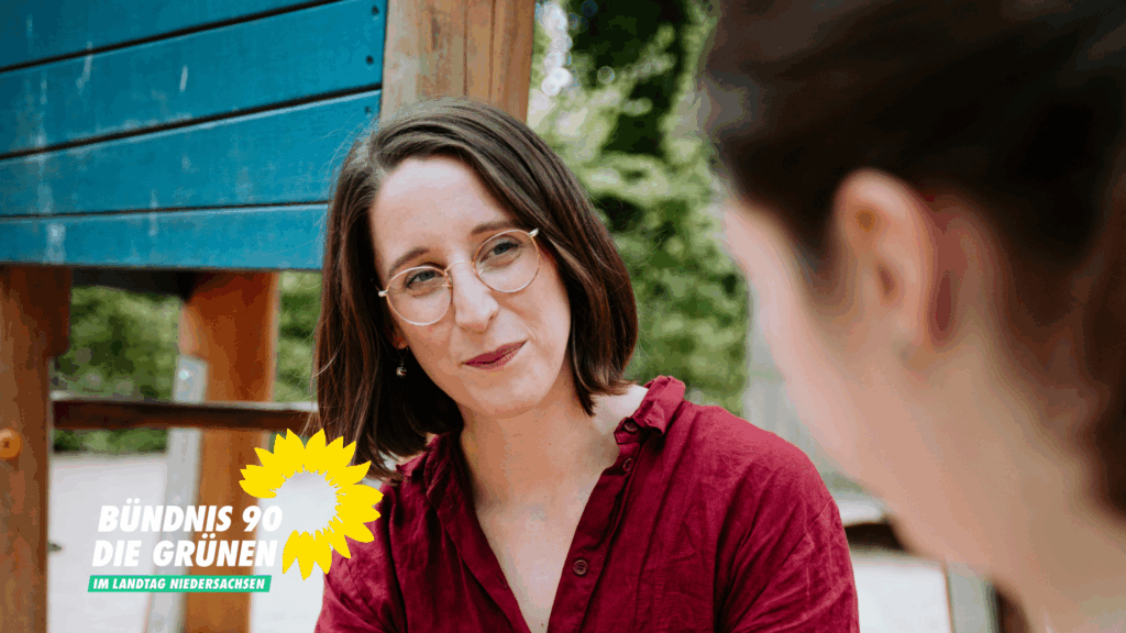 Swantje Schendel sitzt mit einer Mutter auf einem Spielplatz und schaut sie verständnisvoll an.