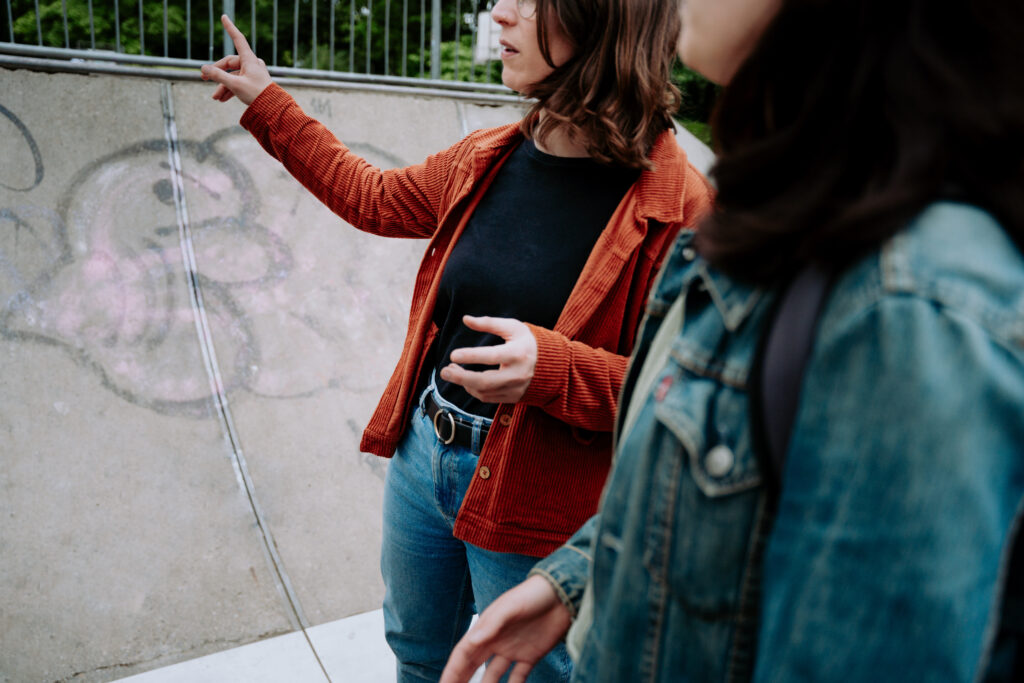 Swantje Schendel mit Gespr&auml;ch mit jungen Menschen, im Hintergrund ein Graffiti.