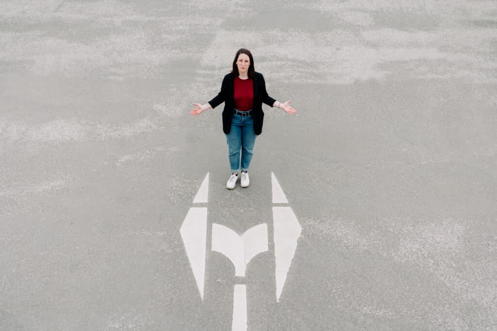 Swantje Schendel vor zwei auf die Straße gemalten Pfeile, die nach rechts und links weisen.