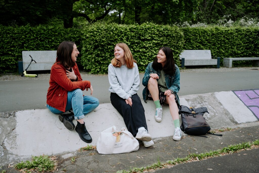 Swantje Schendel im Gespräch mit zwei jungen Frauen im Park
